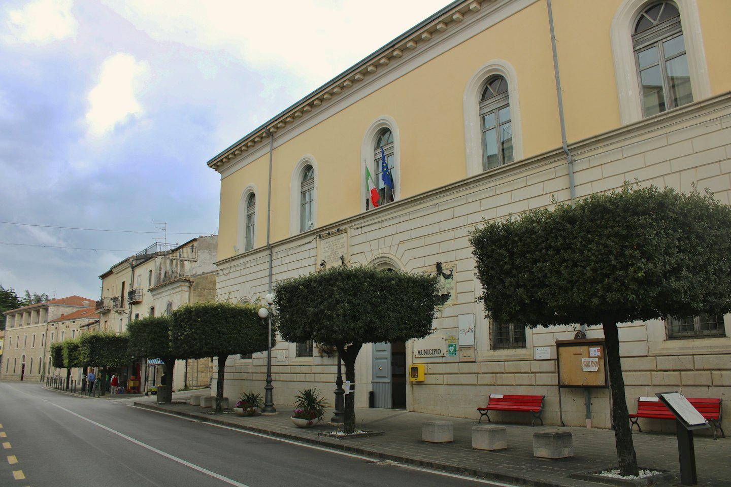 Municipio italiano con bandiera italiana in una strada tranquilla.