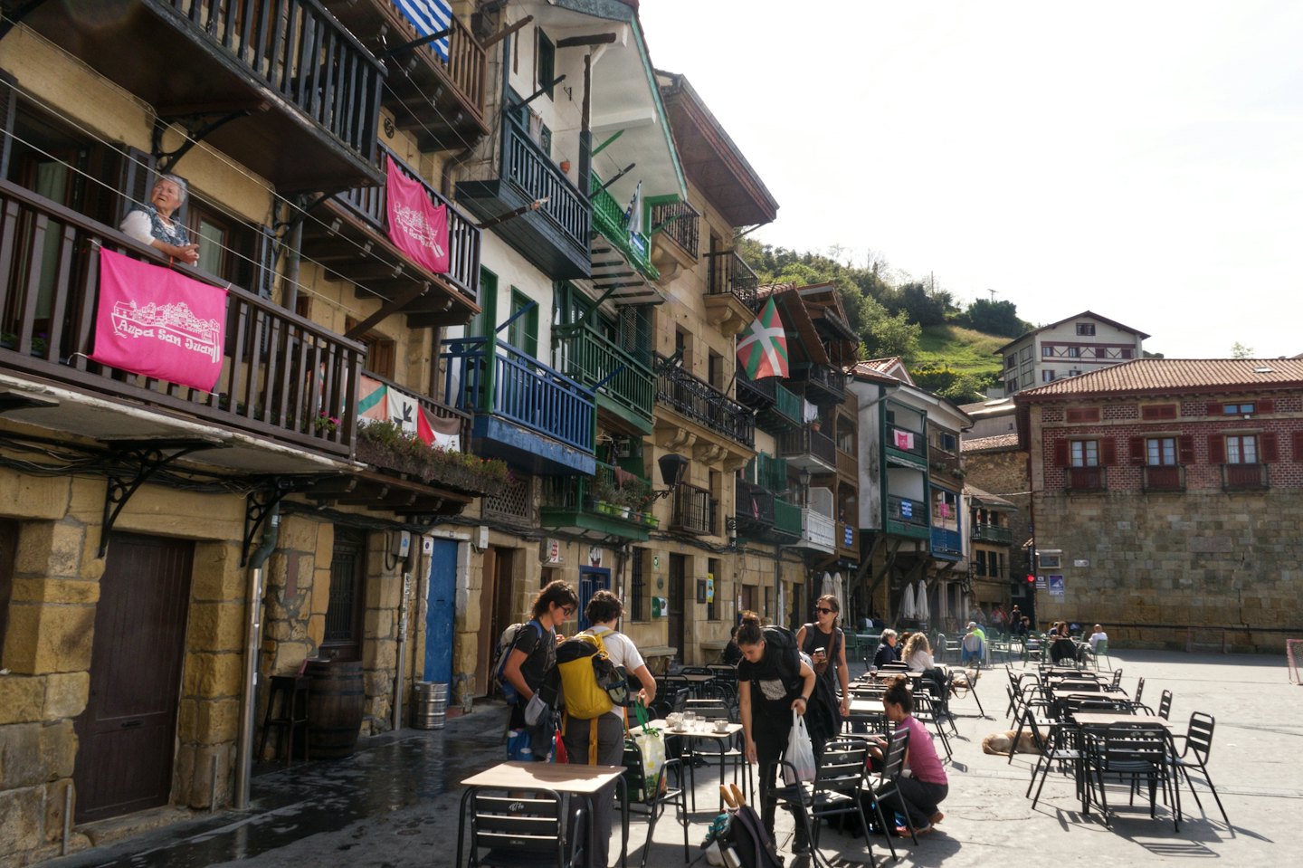 Persone che allestiscono tavoli in una piazza cittadina sotto edifici storici.